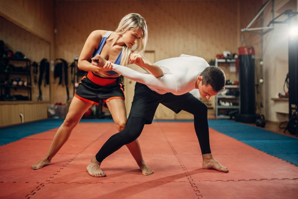Woman makes elbow kick, self-defense workout
